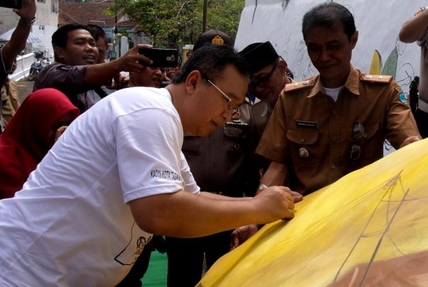 Walikota Tasikmalaya Drs. H. Budi Budiman menandatangani mural payung geulis. (kominfo)